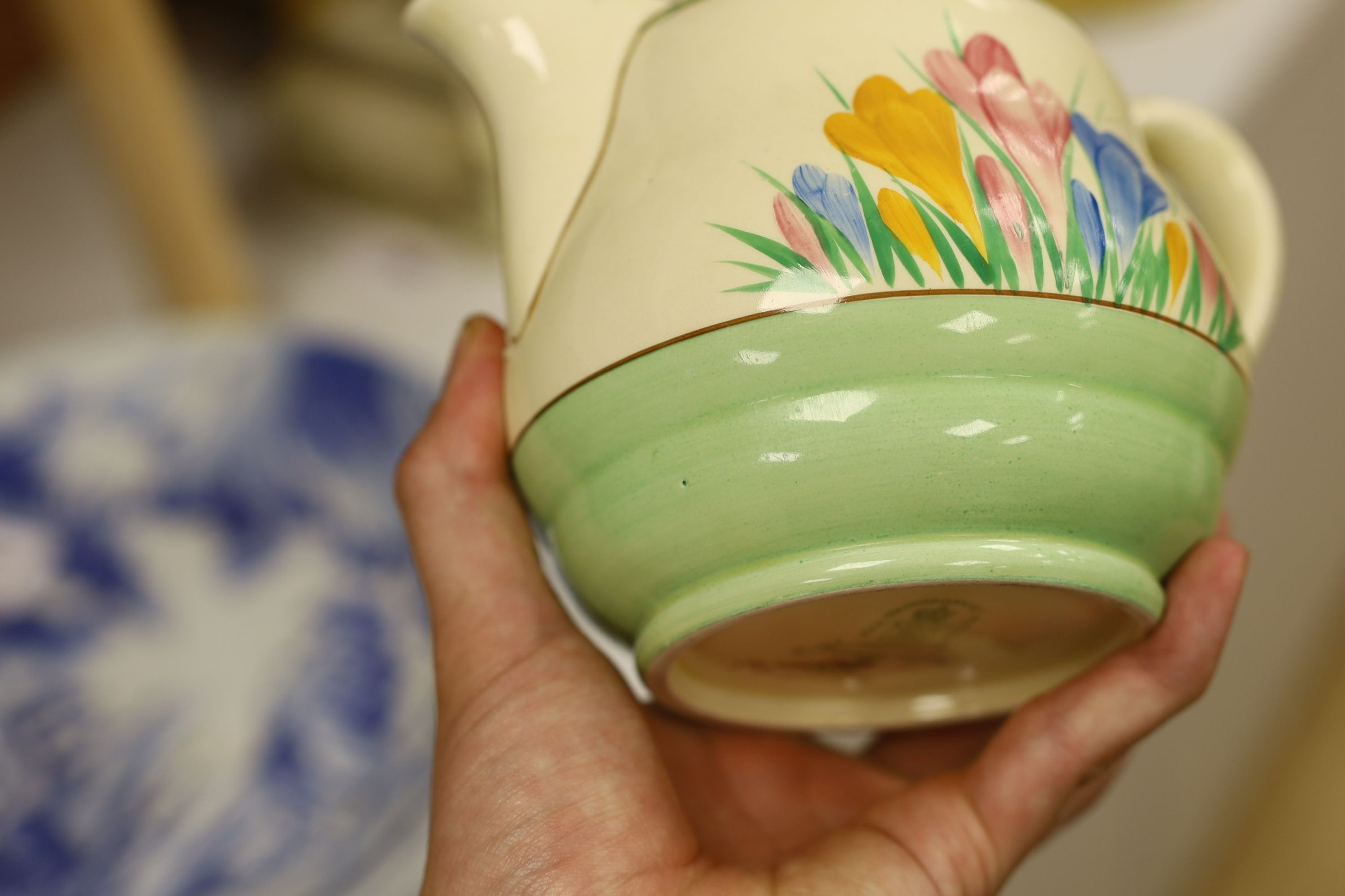 A Clarice Cliff crocus design milk jug and a Bizarre patterned side plate, jug 11.5 cms high